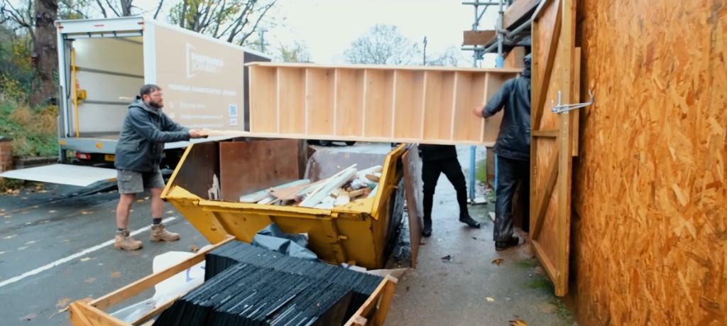 Builders unloading joinery from a delivery truck