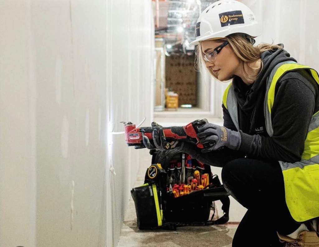 A builder cutting a drywall opening with an oscillating tool