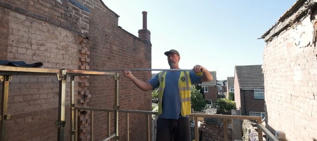A builder measuring on site with a tape