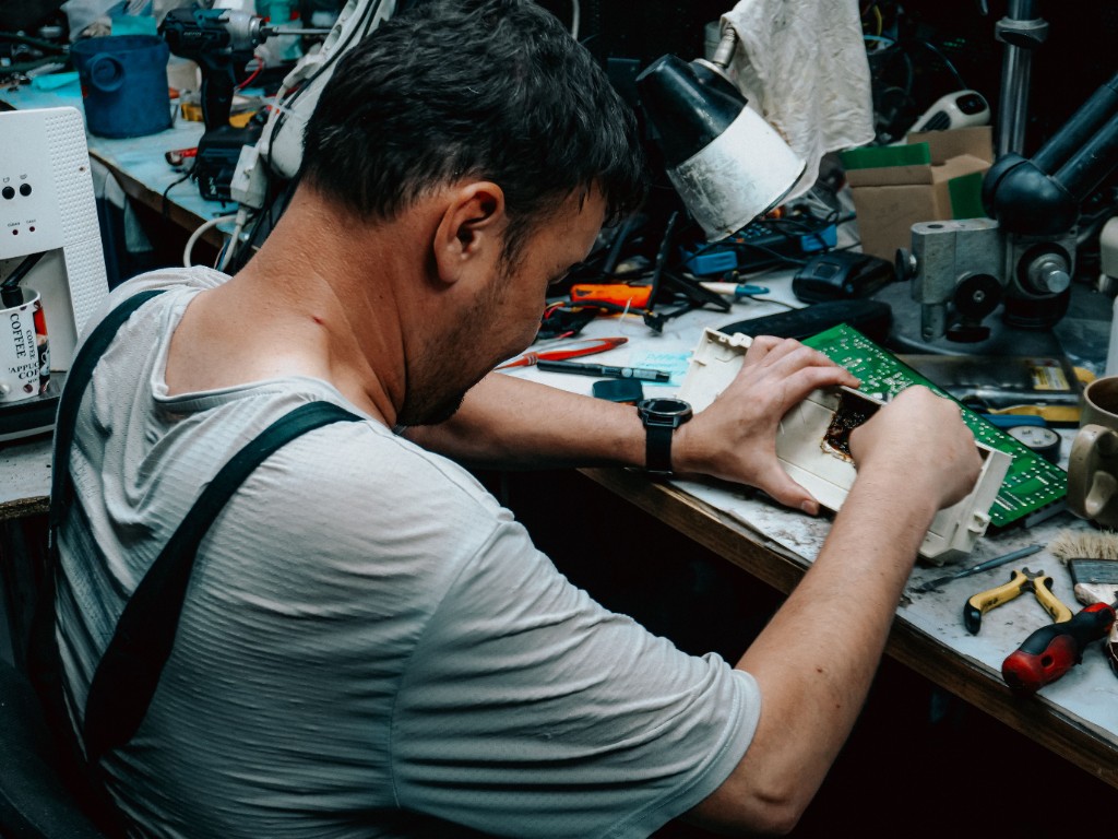 An HVAC engineer repairing a control board at a workbench