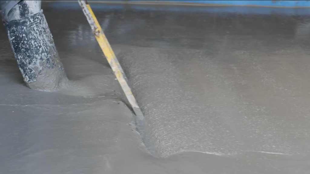 A straight edge cutting through a wet screed