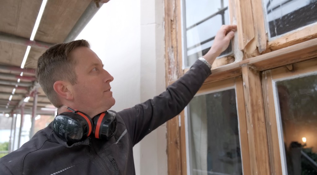 A glazier checking a timber window frame
